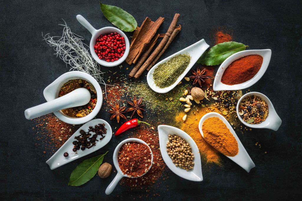 Various herbs and spices on slate cutting board