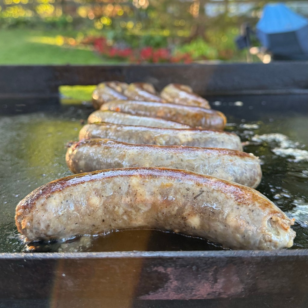 BOR Meats French Onion Brisket sausage sizzling on a griddle.