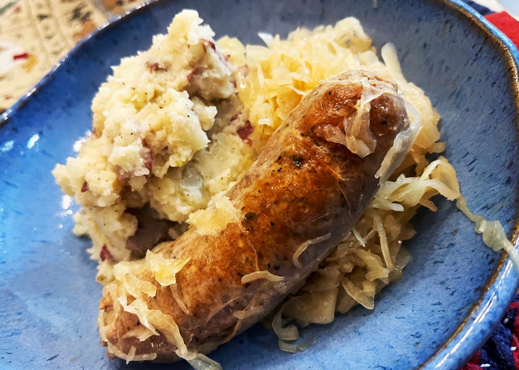 Bratwurst served with sauerkraut and mashed potatoes.